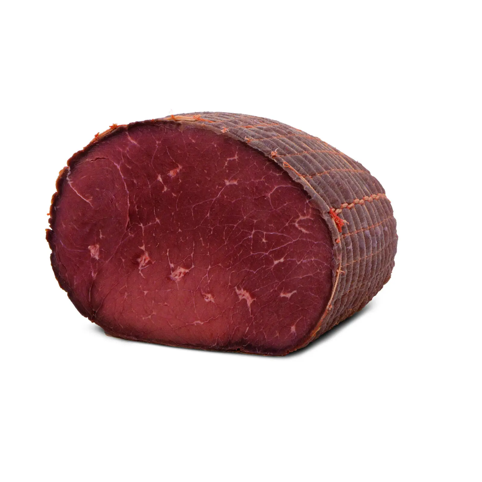 Un primo piano di un intero taglio di basturma, con il suo colore scuro, rosso-marrone che ricorda il roast beef stagionato. La carne è racchiusa in uno strato di spezie stagionate, che le conferiscono un aspetto distinto e strutturato sullo sfondo bianco.