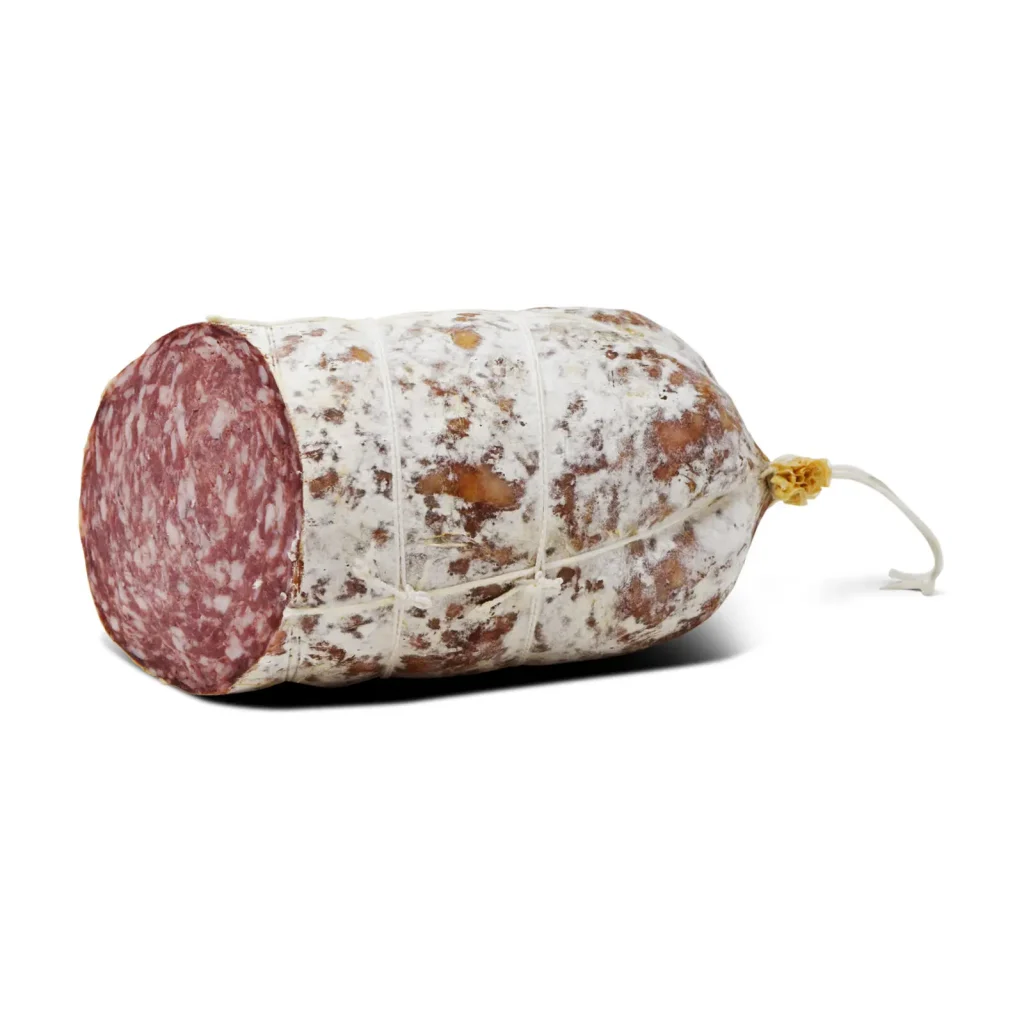 Un grande pezzo di salame con involucro bianco maculato e una sezione trasversale visibile che mostra un motivo marmorizzato di carne rossa e bianca. Il salame è avvolto in una rete con uno spago attaccato all'estremità.